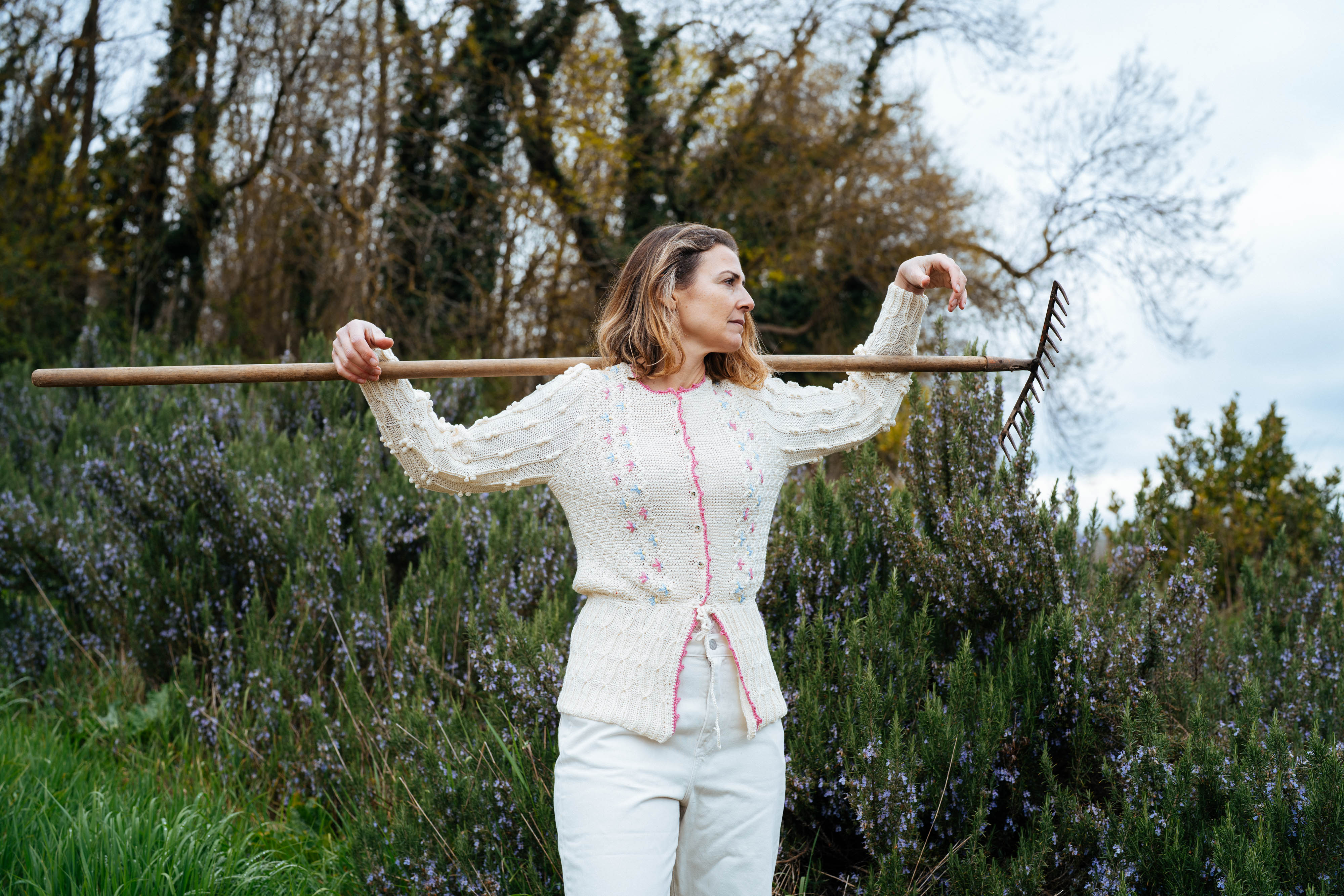 Woman wearing Michaela Buerger Seraphina cardigan in cream cotton in a garden setting